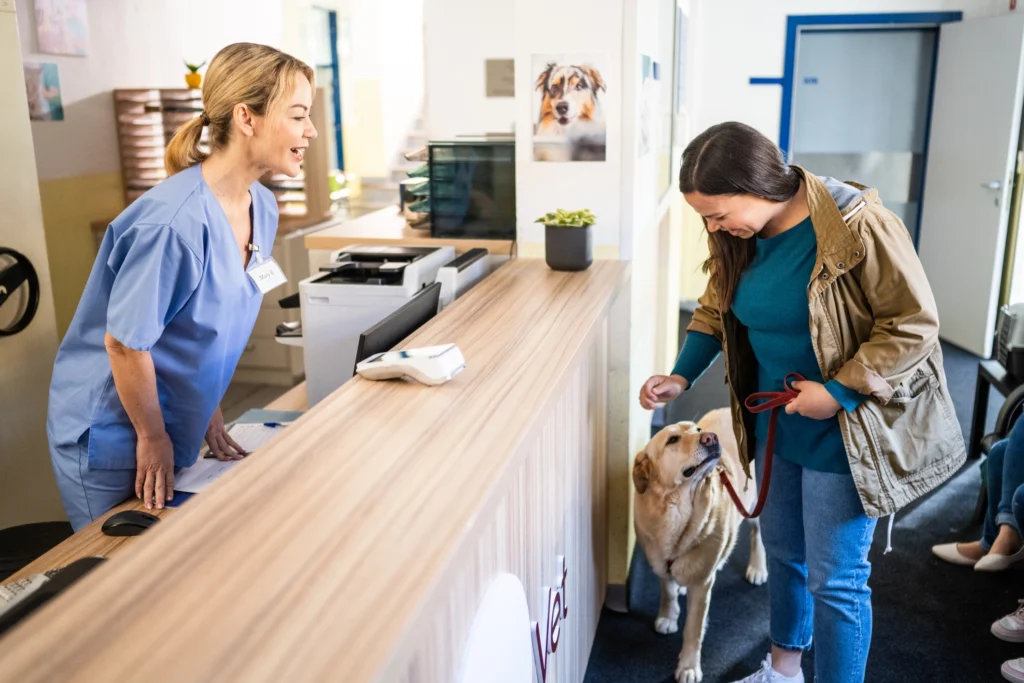 Pet owner and veterinary staff in a welcoming clinic environment—echoing the safer, low-odor spaces BioBond coatings help support